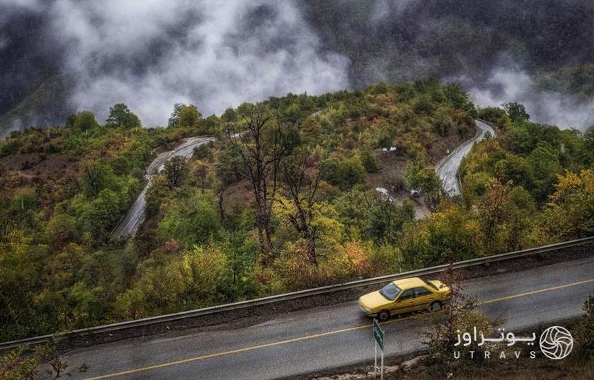 جاده‌ای که در سمت چپش، جنگل و ابر و مه دیده می‌شود و یک تاکسی زردرنگ درحال حرکت در جاده
